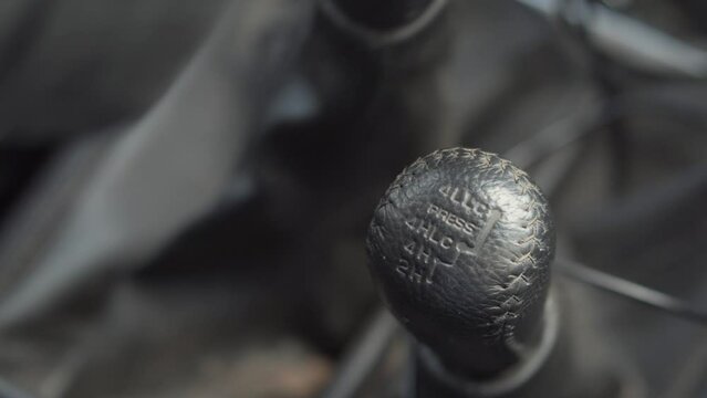 Transfer case shift lever in the car. Close-up of a male hand shifting a manual transmission.