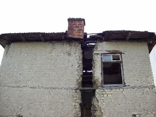 An old house built of mud bricks has split in half under the influence of rains and weather.