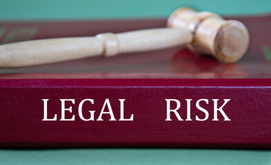 LEGAL RISK - words on a burgundy folder on the background of a judge's gavel