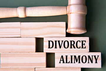 DIVORCE ALIMONY - words on wooden blocks on a white background with a judge's gavel.