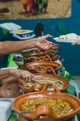 Latina women serving taco stews from their working women's venture