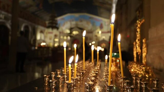 Many candles on a candilo in a church with a blurred background