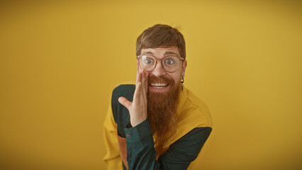 A bearded, redhead man whispers a secret against a vibrant yellow background, embodying a quirky...