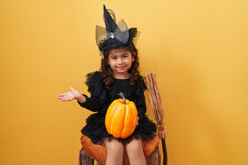 Adorable hispanic girl in witch costume, confidently celebrating her halloween win with a jubilant...