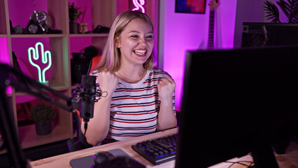 A cheerful woman streams from a vibrant gaming room, illuminated by multicolor led lights at night.