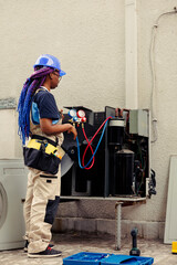 Fototapeta premium Trained serviceman for routine condenser maintenance, assembling set of freon barometer starting work. Certified repairman reading refrigerant pressure in hvac system cooling tank