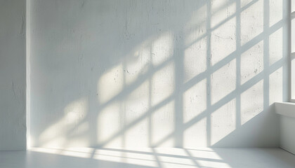 Soft sunlight casting geometric shadows on white wall