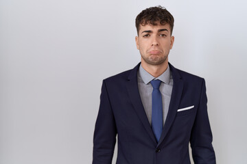 Young hispanic business man wearing suit and tie depressed and worry for distress, crying angry and afraid. sad expression.