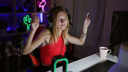 A young woman enjoys gaming at night in her neon-lit room, showcasing technology and lifestyle.