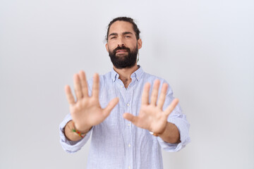 Hispanic man with beard wearing casual shirt moving away hands palms showing refusal and denial...