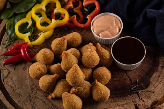 Por&ccedil;&atilde;o de mini coxinhas acompanhada de molhos
