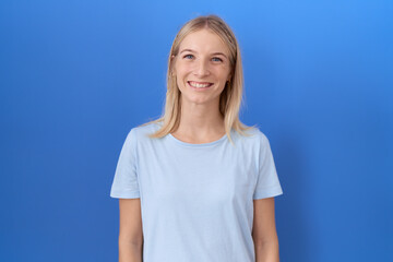 Young caucasian woman wearing casual blue t shirt with a happy and cool smile on face. lucky person.