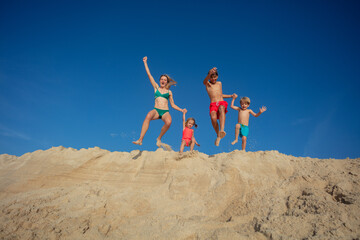 Joyous beach family jump on a sunny day, summer freedom concept