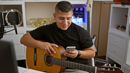 Handsome young latin man, an upbeat musician, heartily engrossed in a melodious chord on his...