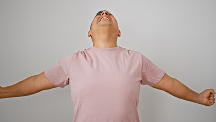 Joyous young latin man, confidently screaming in celebration, happily isolated against a plain...