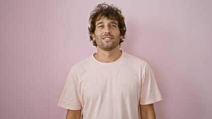 Handsome young hispanic man in casual clothing against a pink isolated background