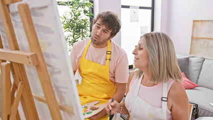 Fototapeta premium In the heart of creativity, two confident artists, man and woman, unleashing their talents drawing together in a relaxed art studio atmosphere