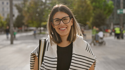 Smiling young woman with glasses standing on a budapest street, embodying beauty and urban life.