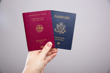 Close up of a female hand holding a German and an American passport