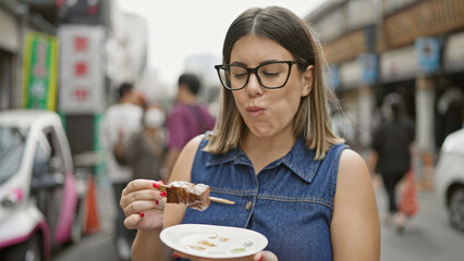 Stunning hispanic woman with glasses savors fresh wagyu beef stick meal at traditional tsukiji...
