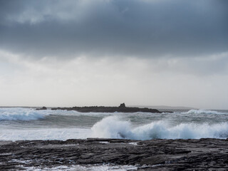 Powerful ocean wave hit rough stone coast in Doolin pier area, county Clare, Ireland. Stunning nature scene in popular tourist area with amazing nature scenery. Nobody. Storm weather. Power of nature
