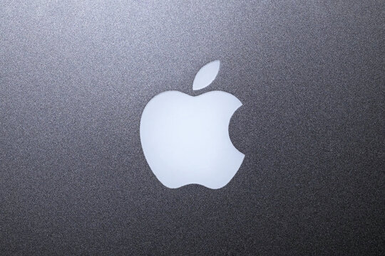 Prague, CZ -06.05.2024: Apple logo on the back cover of a MacBook Pro, iconic branding representing the renowned technology company's product. Editorial
