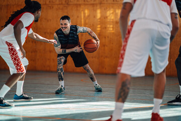 Portrait of a hispanic tattooed man playing basketball with his diverse team