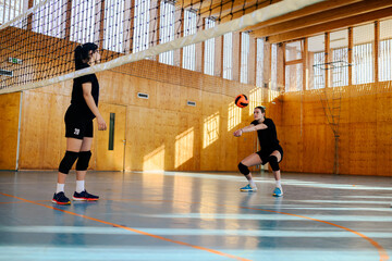 Group of diverse young beautiful girls playing volleyball in a sports hall