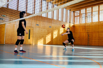 Fototapeta premium Group of diverse young beautiful girls playing volleyball in a sports hall