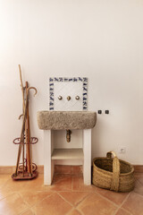 A rustic sink with a wooden sink and some country accessories on the wall