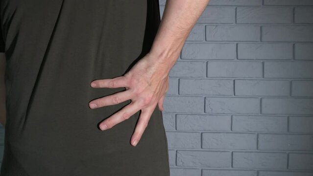 Man suffer from back pain in belt. A man suffer from lumbar pain and wearing the soft corset.