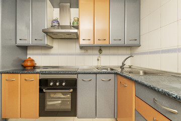 Kitchen with low L-shaped furniture, blue countertop and combined wood and blue doors