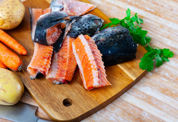 Chunks of raw salmon and fresh vegetables - ingredients for preparing a delicious lunch