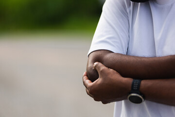 Close up Asian young sport runner black man wear watch he having elbow pain and use hands joint...