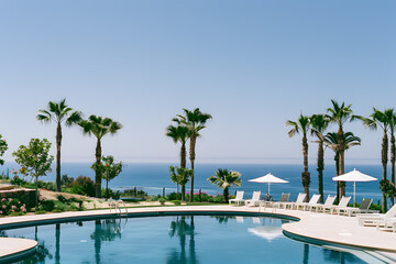 Naklejka premium Swimming pool and sun loungers at stylish tropical spa hotel, summertime banner mockup. Summer travel sales and vacation concept.