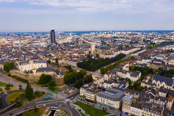 Drone view of ancient Chateau des ducs de Bretagne and Nantes Cathedral on background of downtown with modern skyscraper in summer, France..
