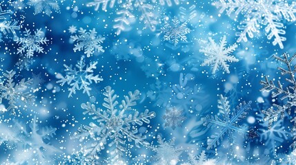 Snowflakes sparkling on a frosty blue background. Winter wonderland and holiday season concept. Design for wallpaper, greeting card.