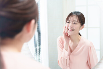 洗面台で鏡を見る女性　スキンケア　アンチエイジングイメージ