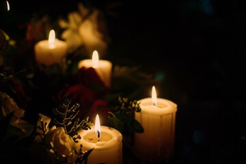 Photo of burning mourning candles on a table against a black background. Lighting candles for bad events, tragedies, in memory, memorial candles, reverence, rest in peace.
