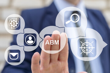 Business man working on virtual touch screen presses abbreviation: ABM. Concept of Account Based...