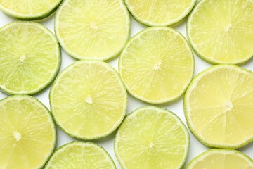 Fresh juicy lime slices on white background, flat lay