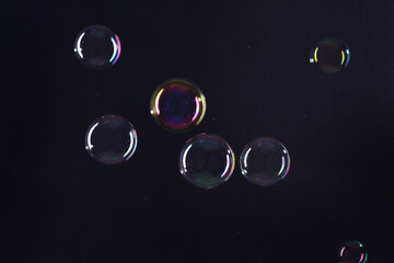 Obraz premium Beautiful transparent soap bubbles on dark background