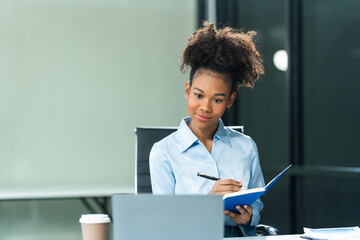 Young female African American in a blue formal shirt with afro brown hair works as a Market...