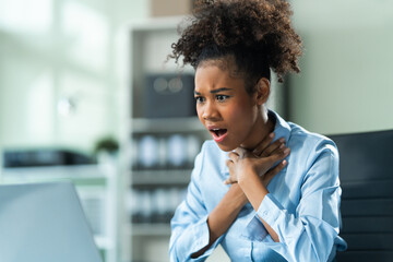 A young African American woman with Afro brown hair in a modern office experiencing panic, business-related stress, frustration, and anxiety. - Powered by Adobe