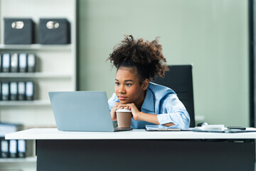 A young African American woman in a blue formal shirt with afro brown hair experiences office...
