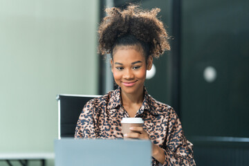 A young African American woman in a blue formal shirt with afro brown hair works as a product...