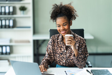 A young African American woman in a blue formal shirt with afro brown hair works as a product...