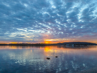 Fototapeta premium Sunrise over the bay water with clouds and reflections