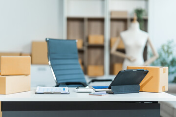 Parcel boxes neatly arranged on shelves, placed next to a laptop on a table. Running an SME from a home office, packaging is a vital aspect of the booming online shopping industry.