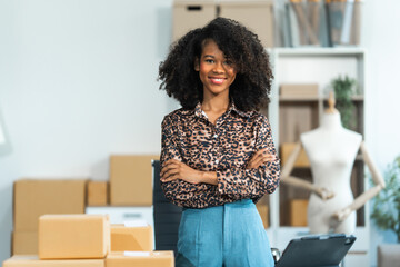 A young African American woman with afro brown hair works in a modern office, managing her online...